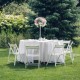 Round table covered with a 90-inch white polyester tablecloth, ideal for weddings and outdoor events.